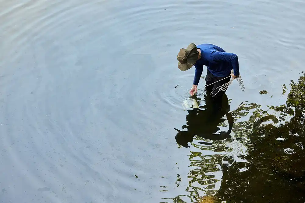 a koi pond cleaning technician testing the water quality